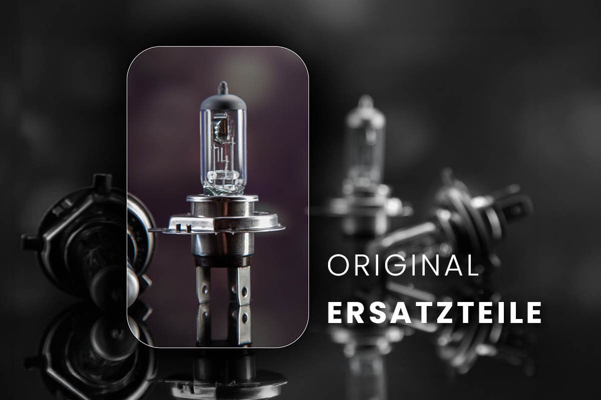 Im Vordergrund ist eine einzelne Autolampe zu sehen, im Hintergrund liegen weitere Ersatzlampen. Das Bild steht für originale Ersatzteile für das Fahrzeug.